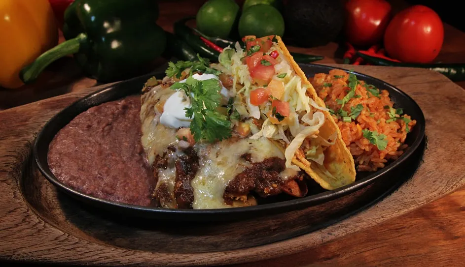 A platter with a taco, an enchilada and a chimichanga, rice and beans