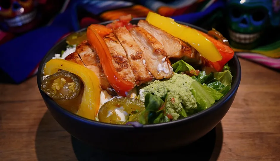 Fajita salad with sliced chicken, peppers and guacamole