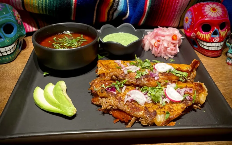 Quesabirrias with beef consommé for dipping and pickled onions
