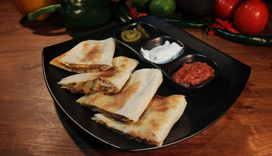 Quesadilla wedges with salsas and sour cream