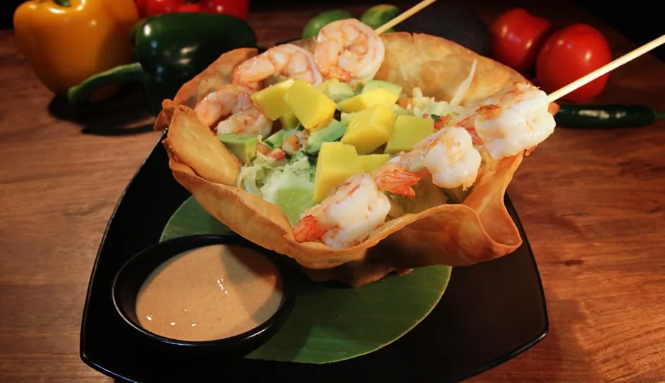 A salad served in a crisp tortilla bowl